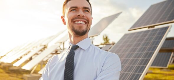 Glad man framför solceller